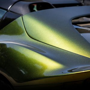 pexels-photo-32692331-32692331 Shiny green sports car reflecting sunlight, showcasing sleek and modern design.